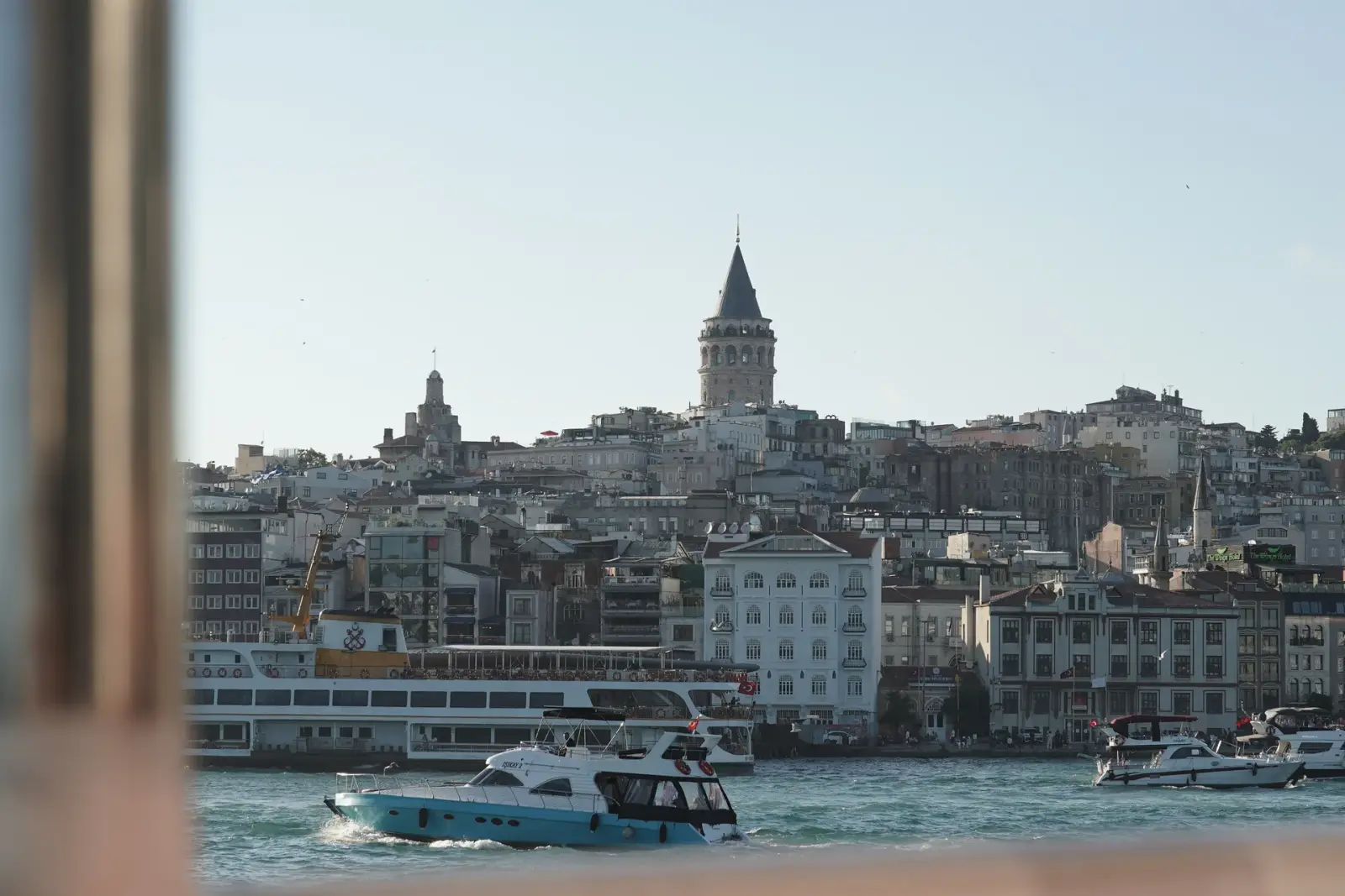 Galata Tower rising above the rooftops of Karaköy, seen from the boat
